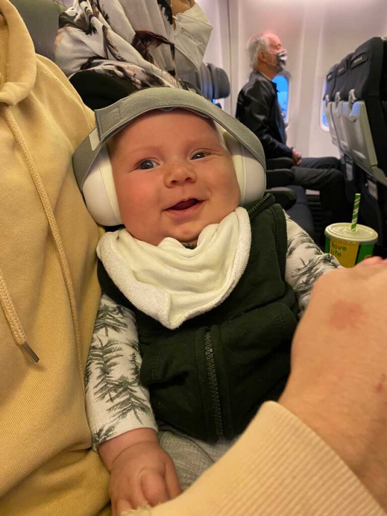 a baby on a plane wearing noise cancelling headphones.