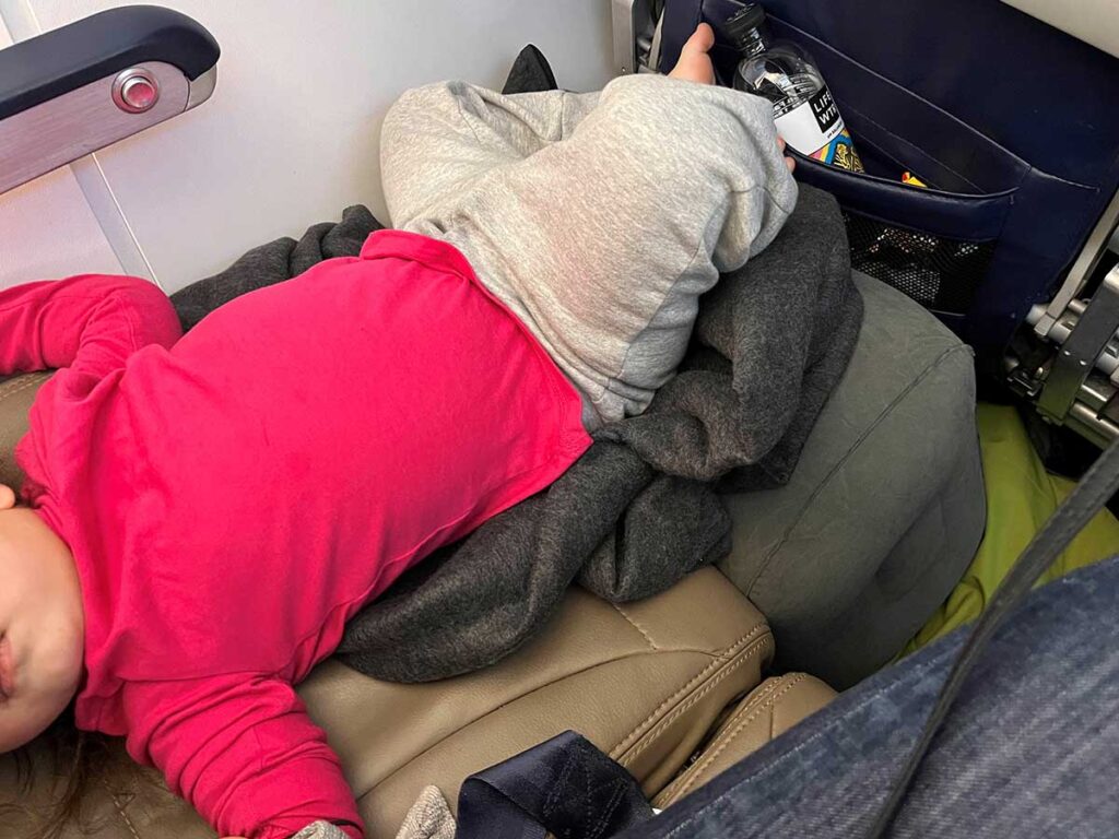 a toddler using a budget inflatable airplane travel bed.