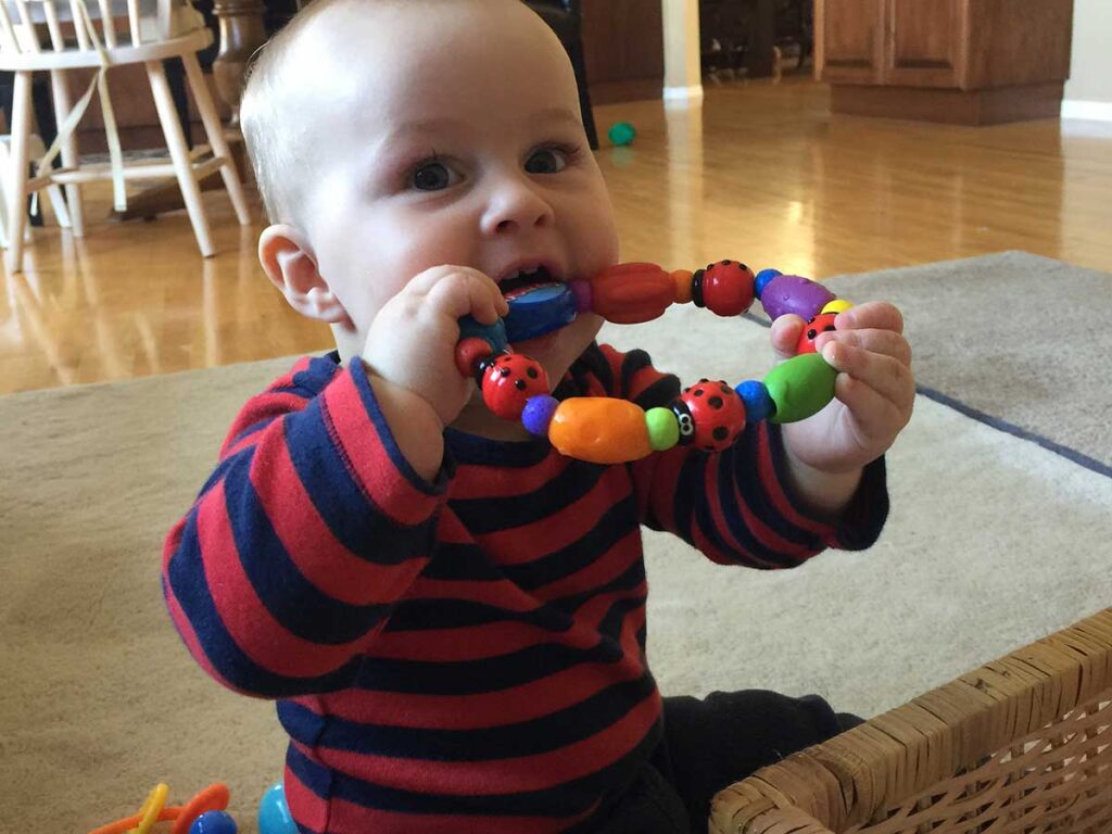 baby playing with nuby travel toy.