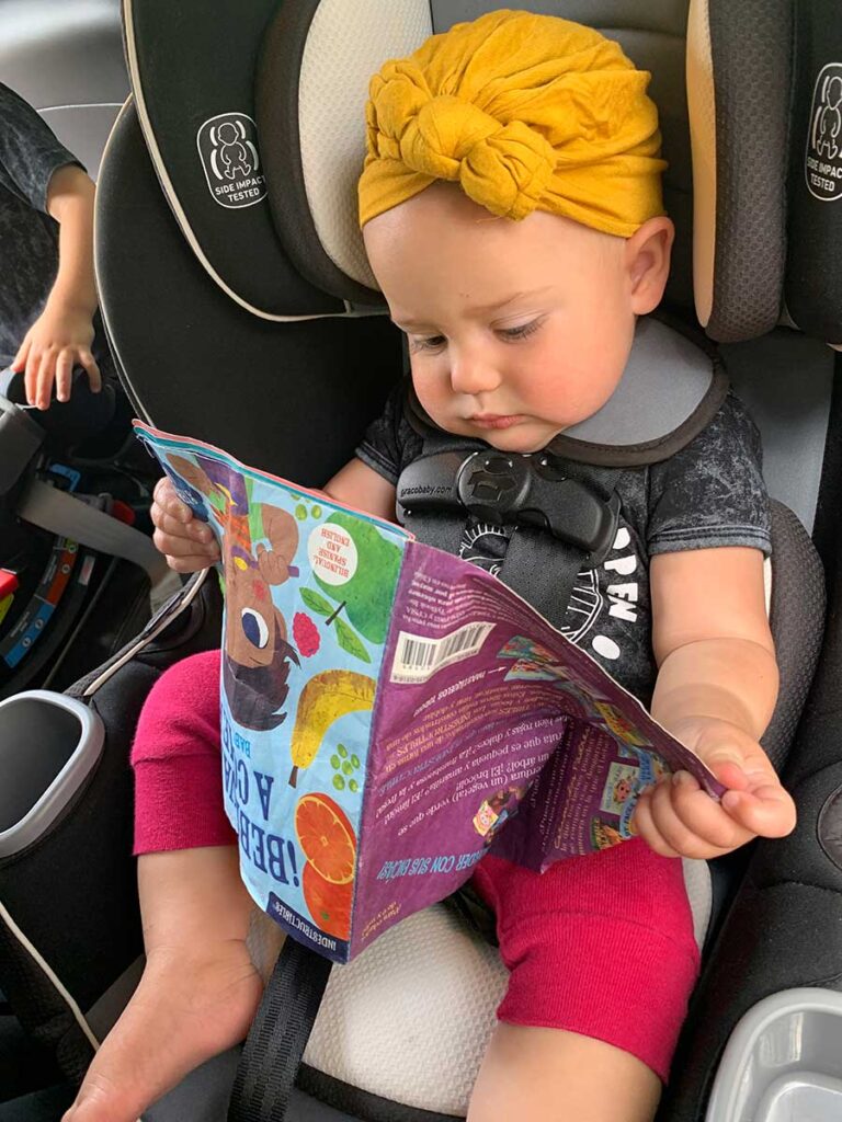 baby in car seat looking at indestructibles baby books.