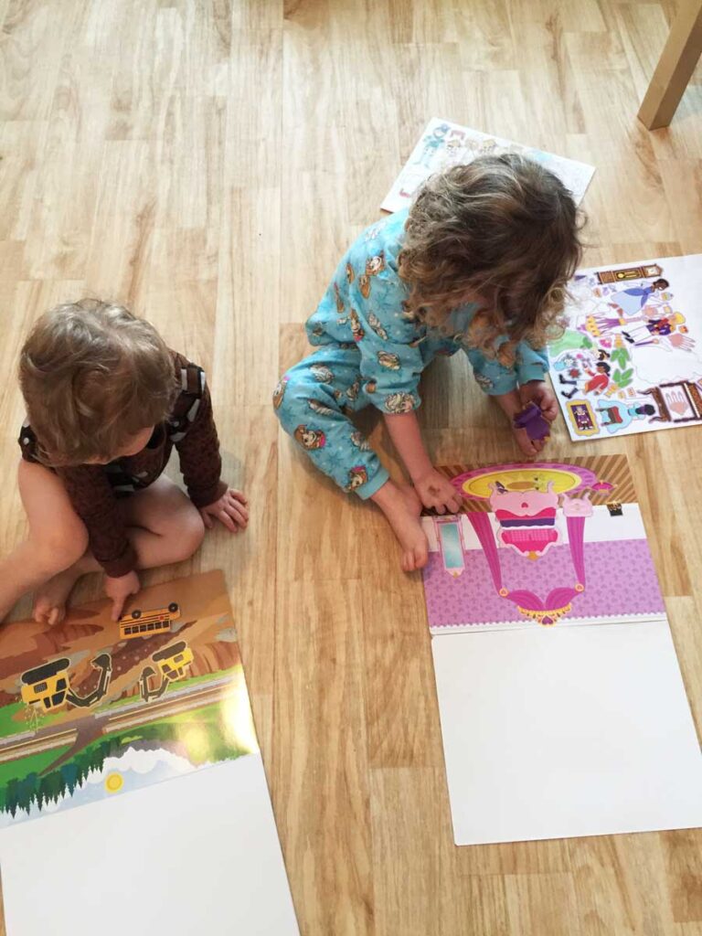 3 year old and older sibling playing with Melissa & Doug Reusable stickers - best travel toys for 3 year olds.