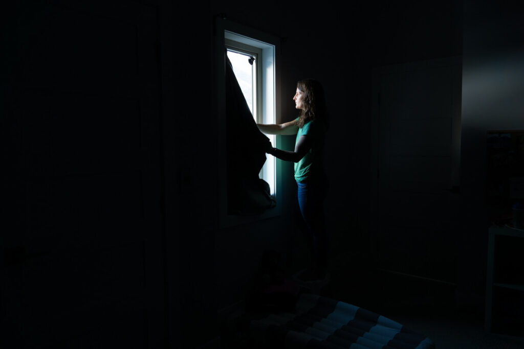 woman installing Sleepout portable blackout blind