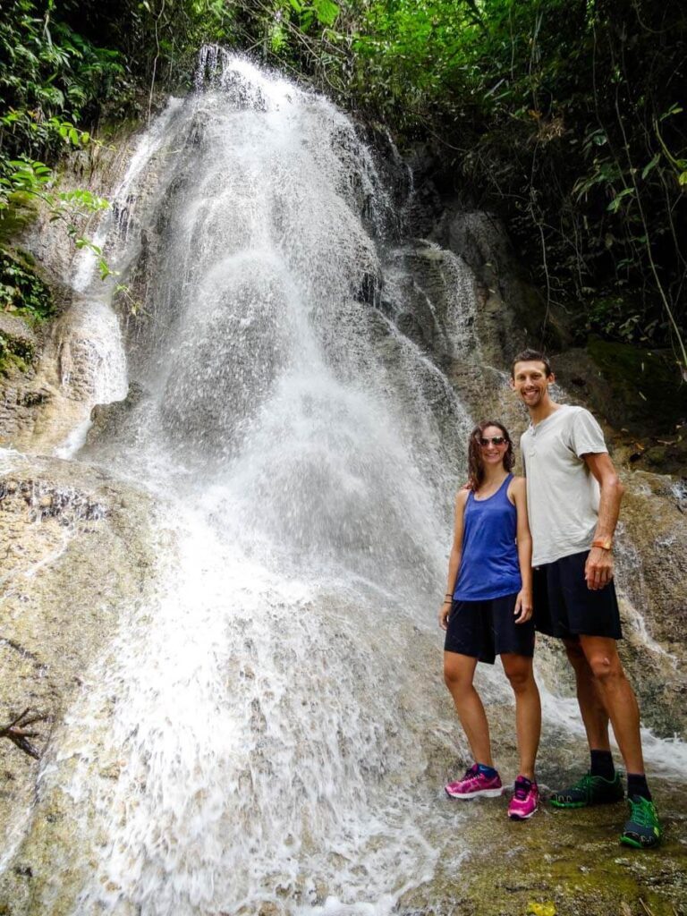 Two adults standing in front of waterfall