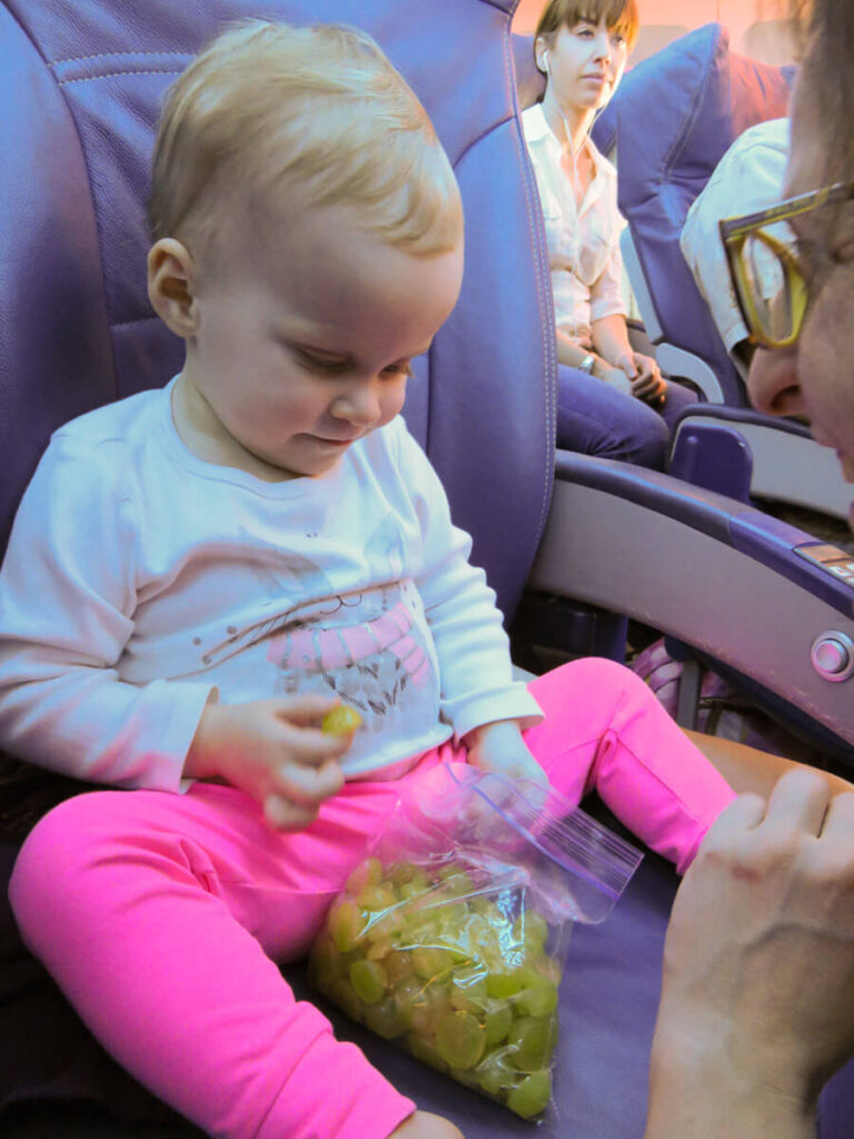 toddler eating grapes on airplane (toddler plane snacks)