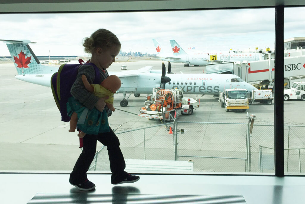 toddler at airport with planes in background