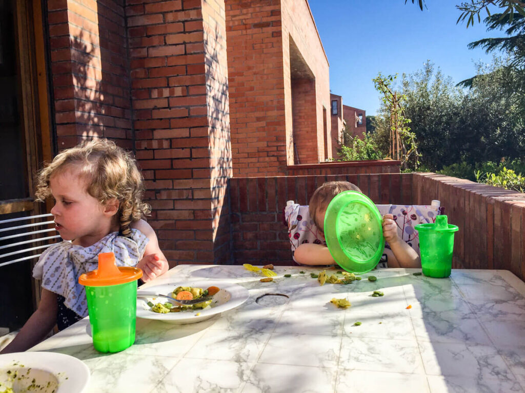 toddlers eating at table with travel food containers