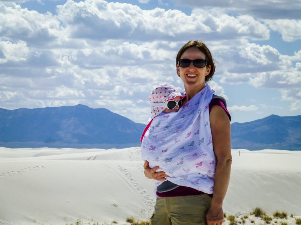 mother with baby in carrier wearing beach baby sunglasses