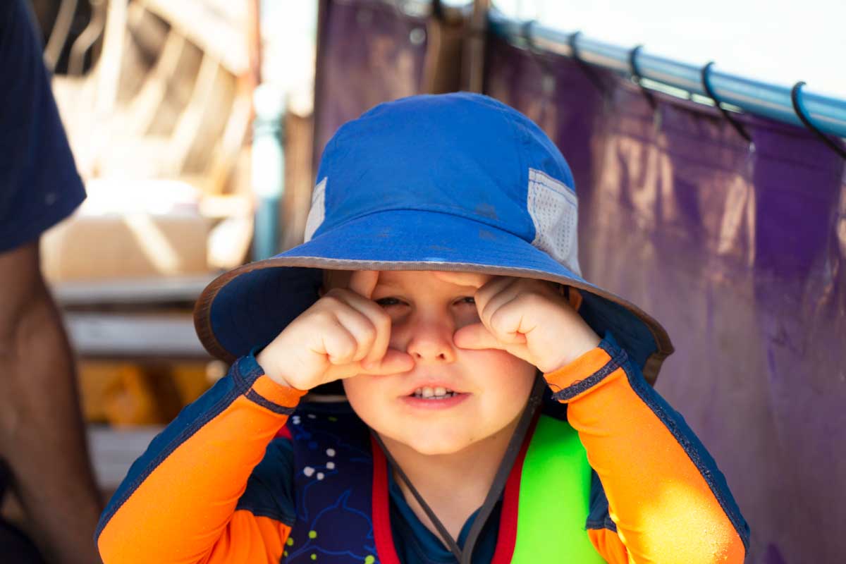 toddler boy posing in blue sun hat for toddlers