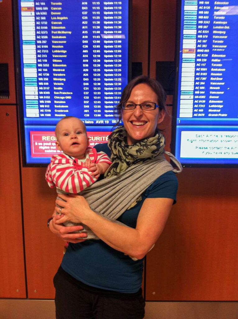 a happy mother and baby at the airport awaiting an international flight with a baby