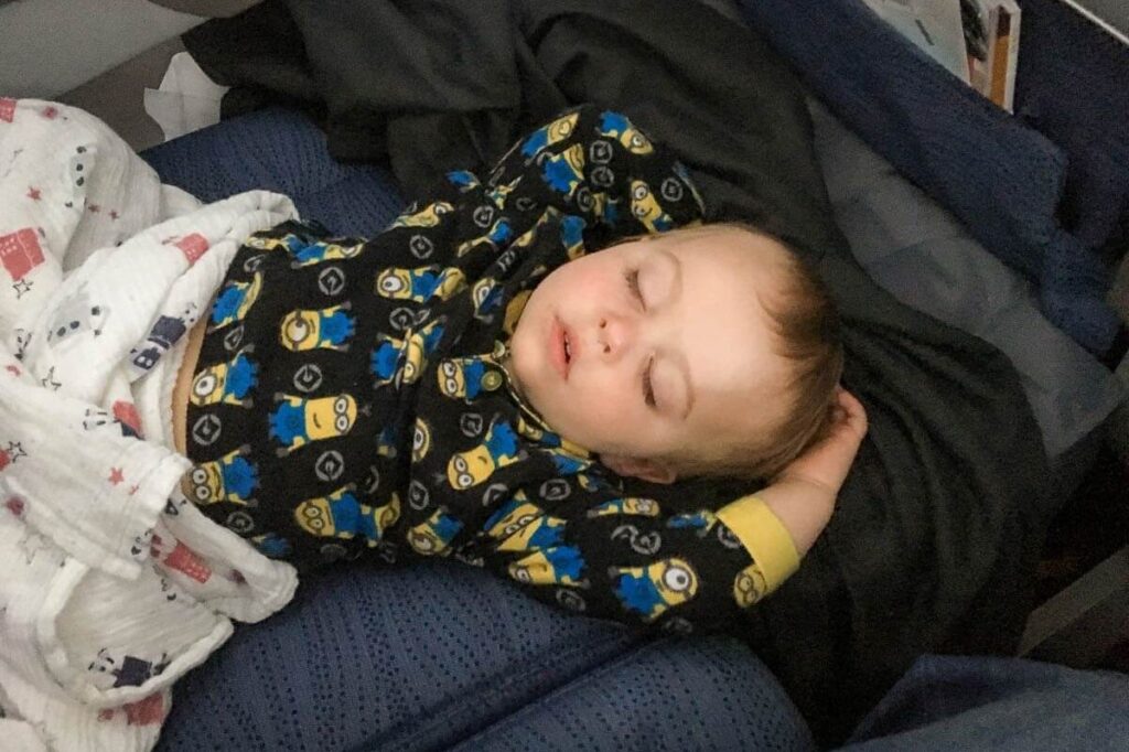 a toddler sleeping on plane.