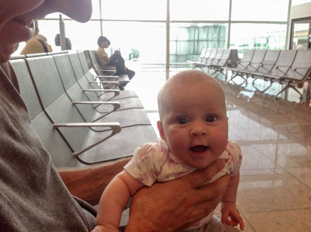 a father and daughter play in the airport waiting for an international flight