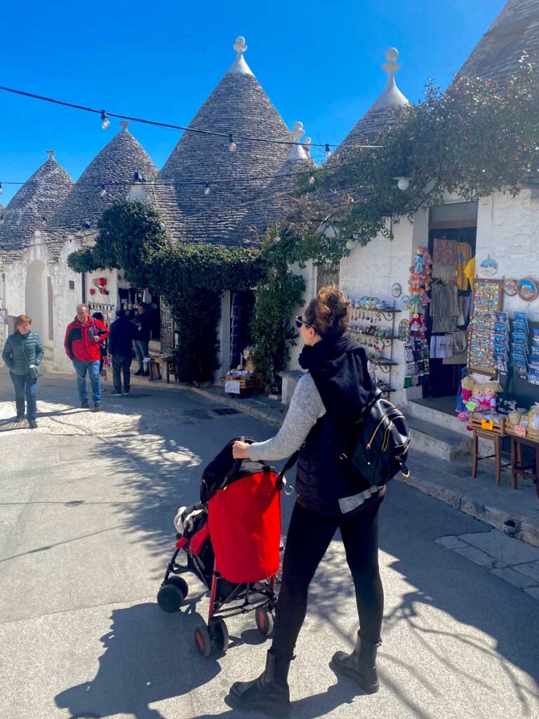 Woman walking in Alberobello with a stroller