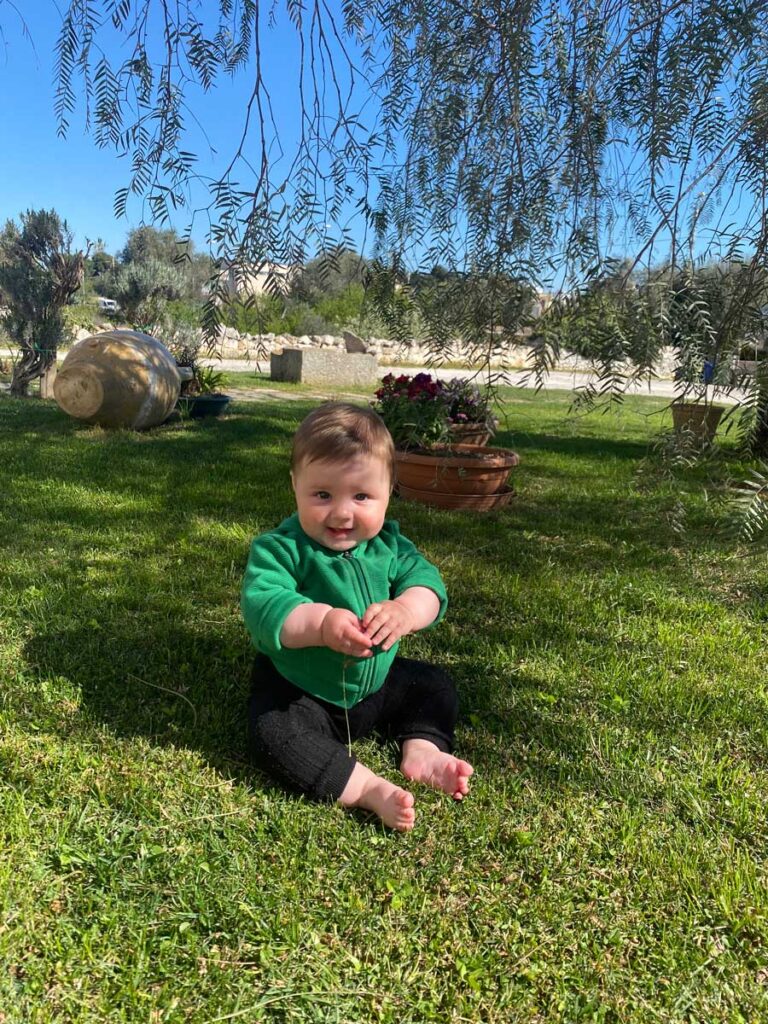 Baby in Grass at Trullo Isabella - where to stay with baby in Puglia Italy