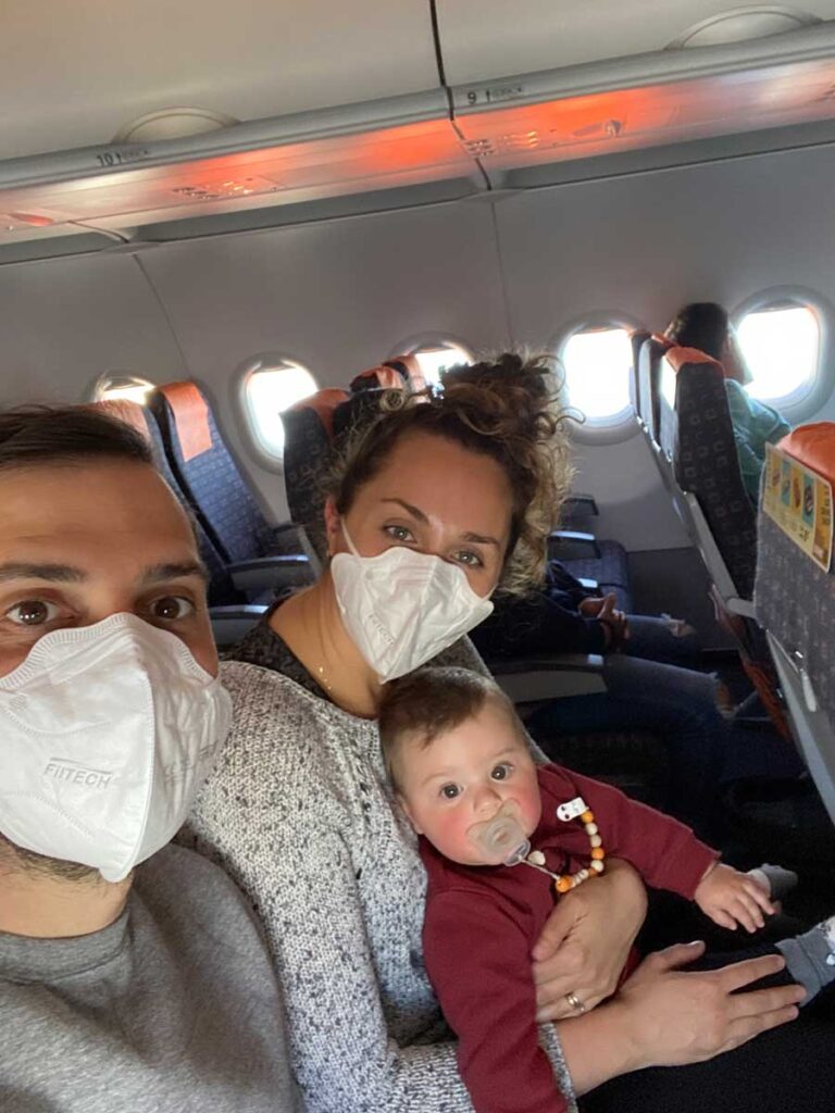 First flight with a baby - parents holding baby on airplane