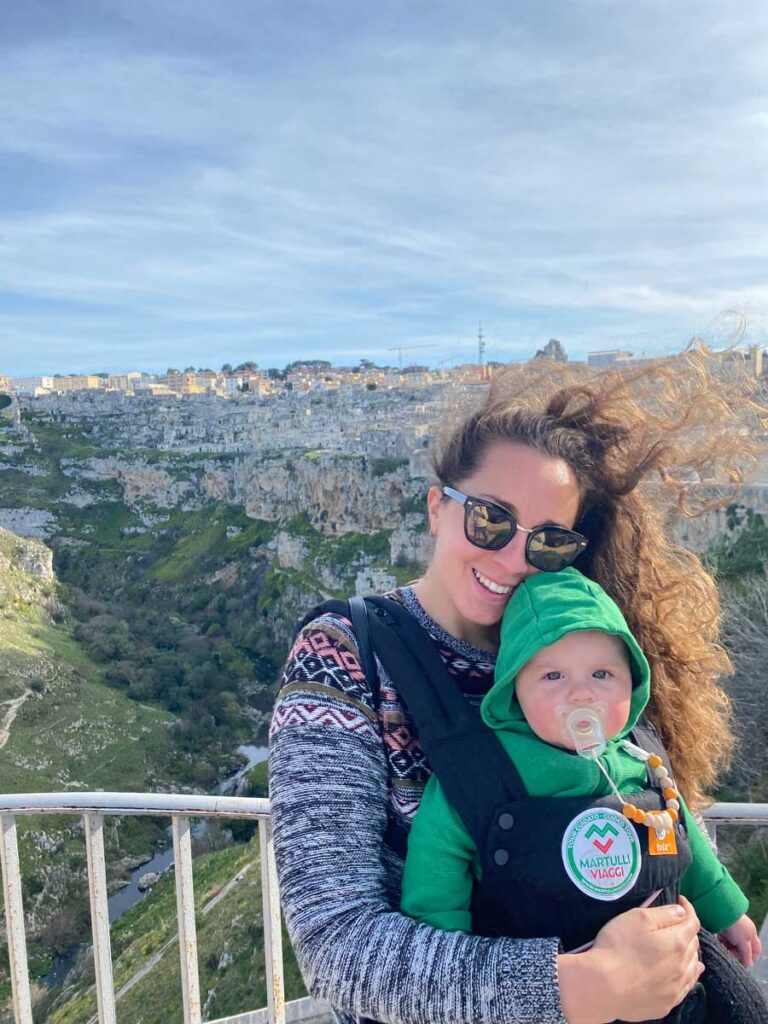 woman holding baby in carrier - Matera Italy