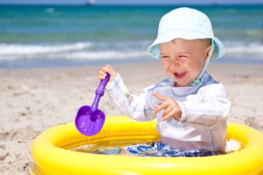 baby playing in inflatable pool on beach - baby beach hack