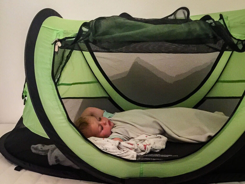 Toddler sleeping in KidCo PeaPod Plus travel tent