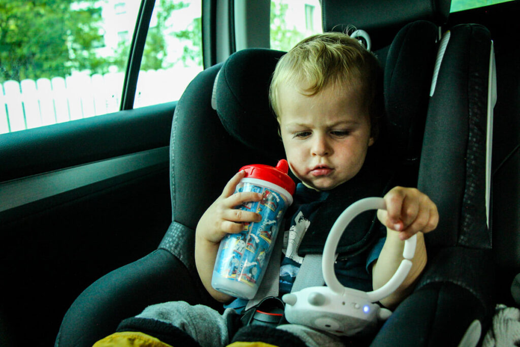 toddler in car seat with playtex sipsters sippy cup