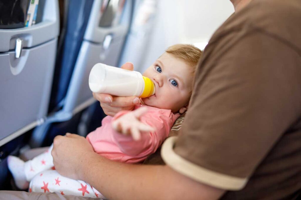 baby drinking from bottle on airplane