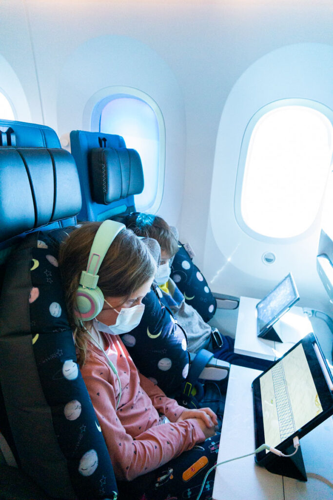 Kids using Seat to Sleep travel cushion on plane