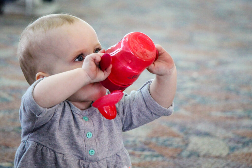 baby in airport drinking from sippy cup