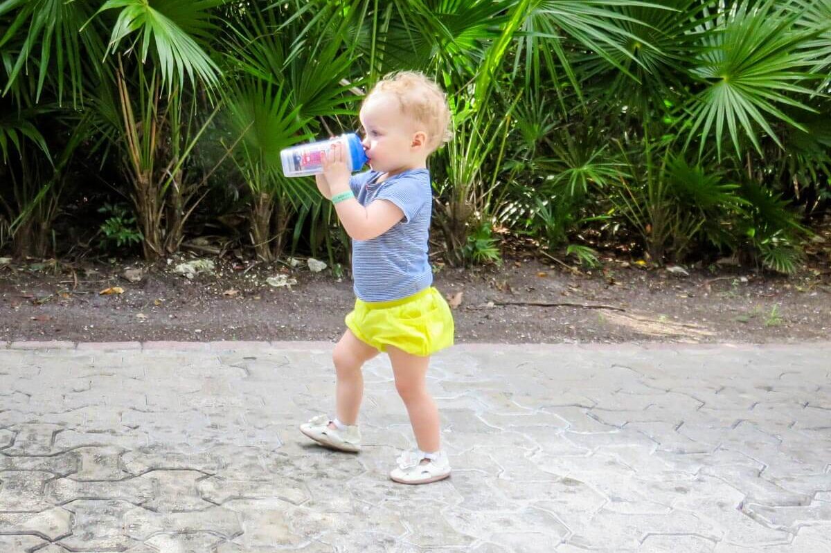 toddler walking drinking from sippy cup for travel