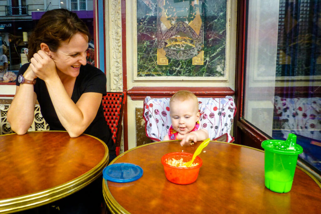 eating out with baby in Paris - Baby in travel high chair with travel sippy cup on table