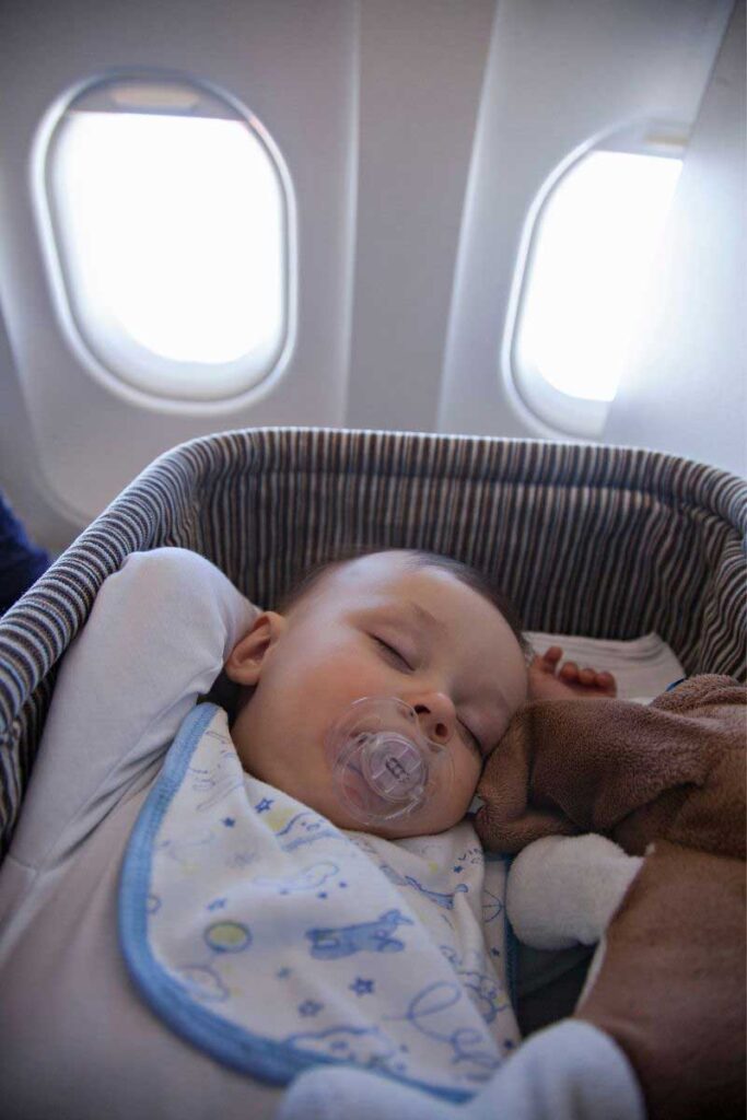 baby sleeping in baby bassinet for flights.