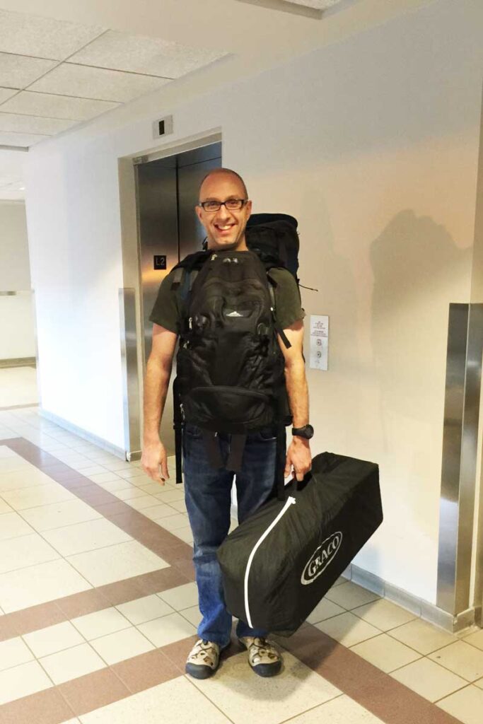 Dan Brewer, of the Baby Can Travel blog, carries a pack n play as carry-on onto an airplane.