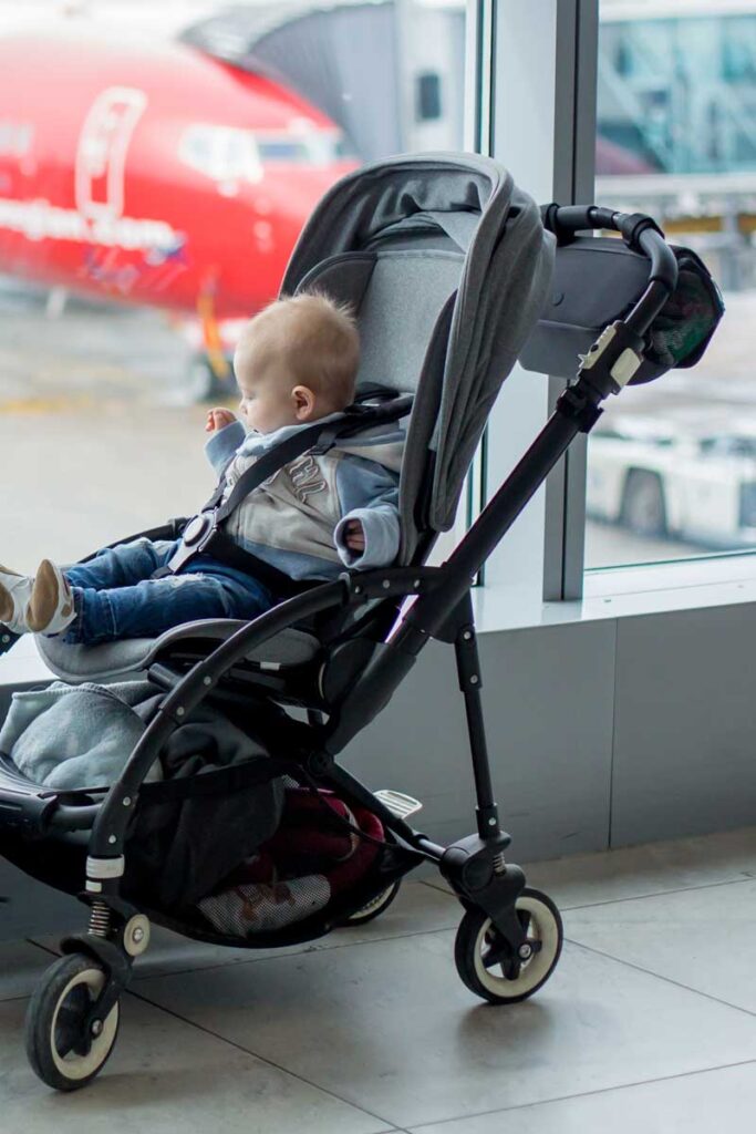 a baby in a travel stroller at airport