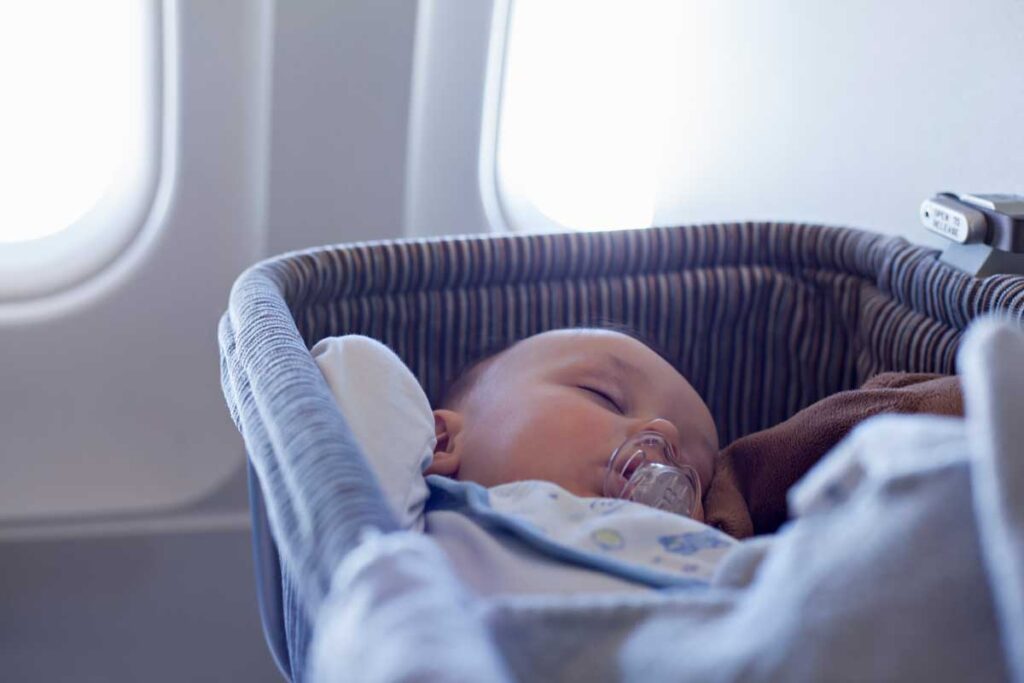 sleeping baby in airplane bassinet.