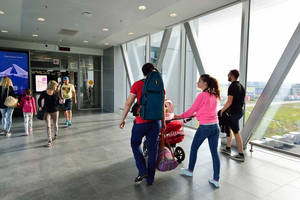 couple in airport with woman pushing stroller