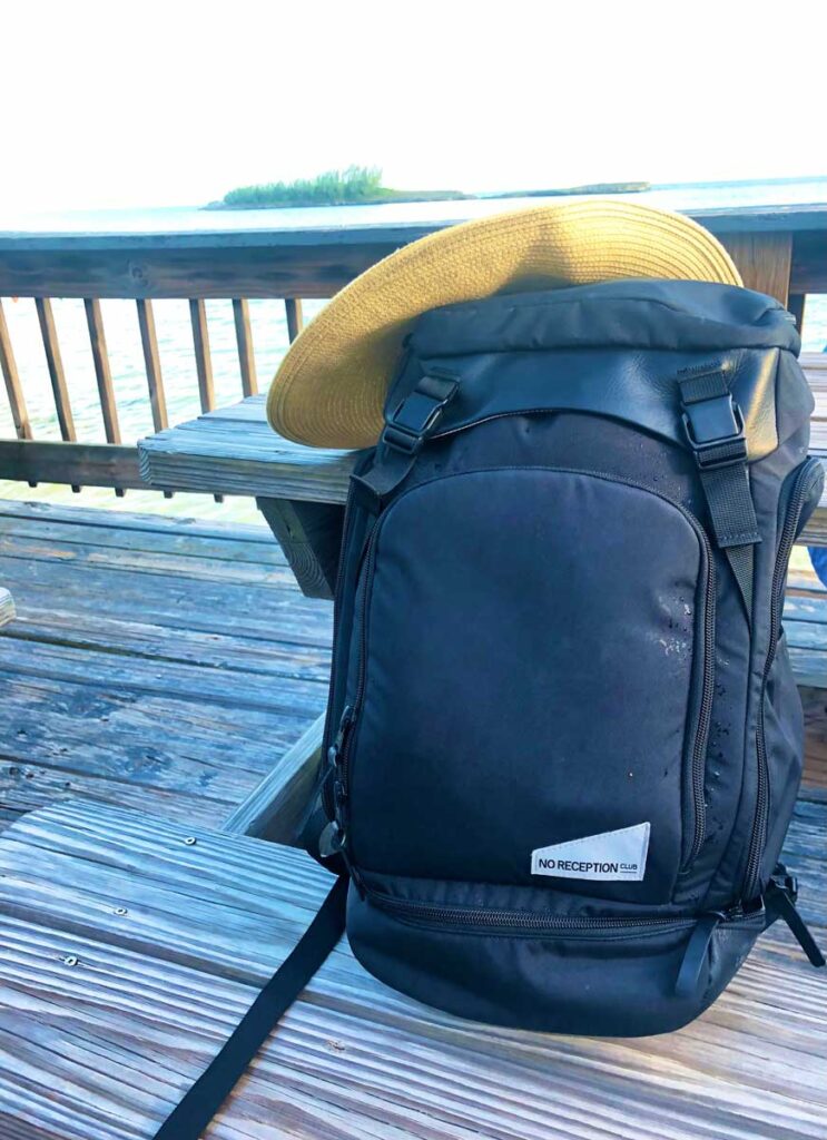 The Getaway Bag by No Reception Club on a table outside with a hat placed on it