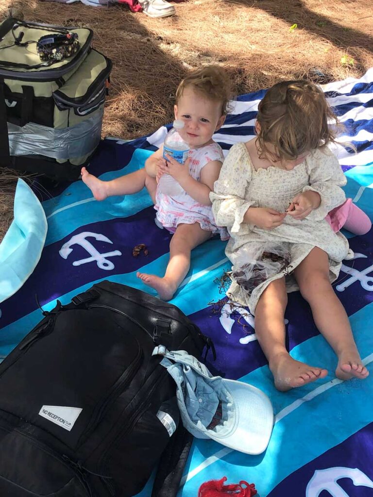 baby and toddler on beach blanket