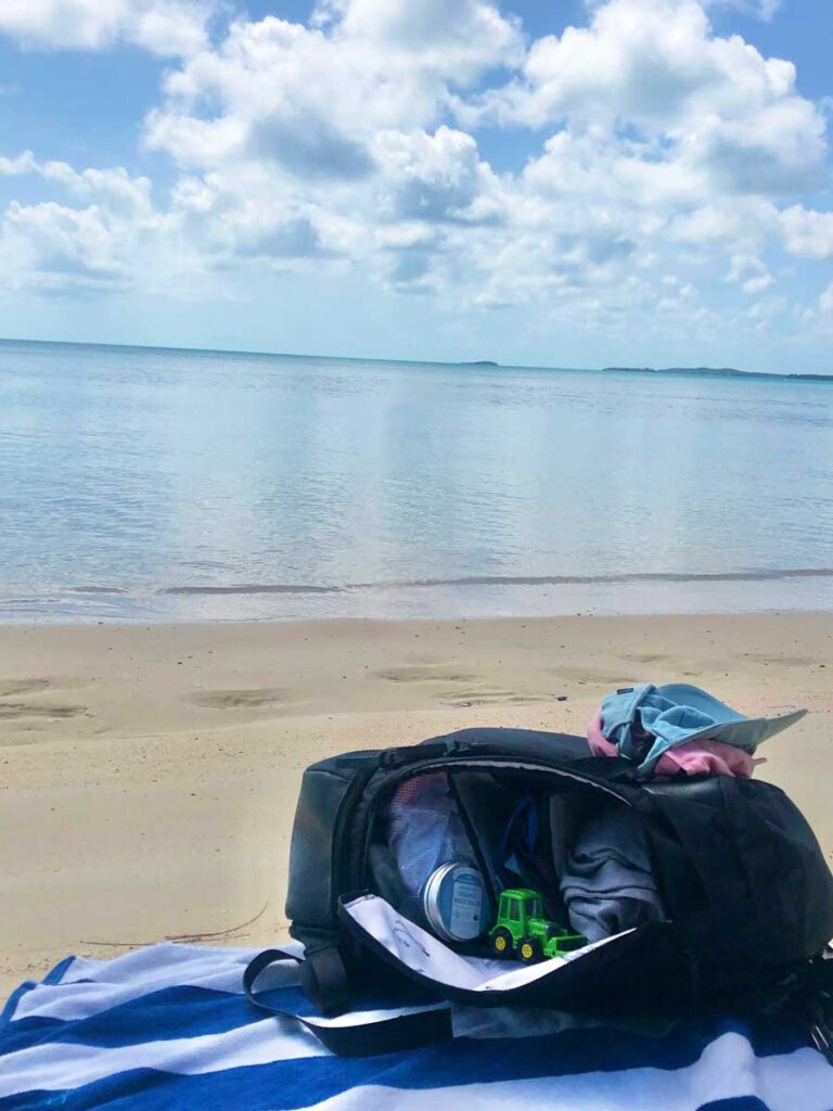 No Reception Club Getaway Bag on the beach, half open showing items inside