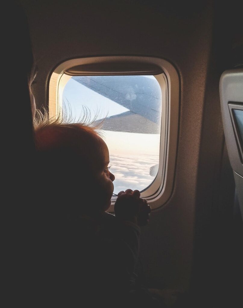 baby on airplane looking out window