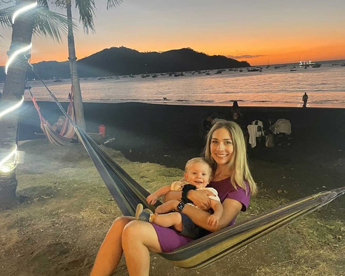 Woman holding baby on beach in Costa Rica at sunset