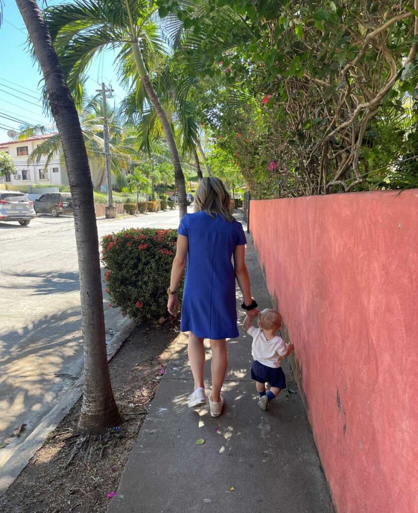 woman walking down the street hold hand of toddler in Costa Rica