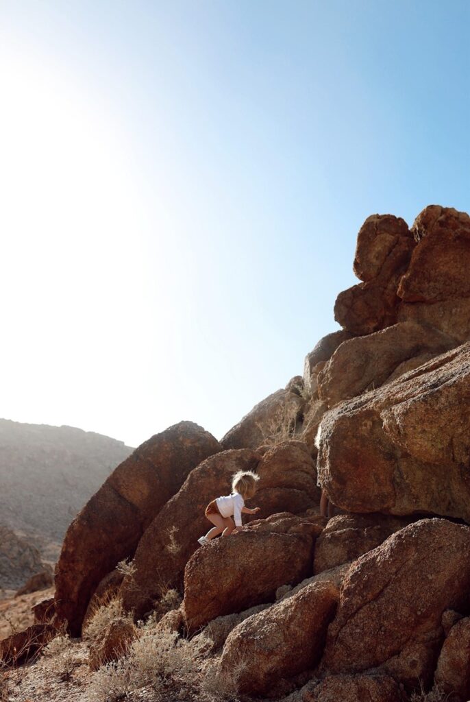 toddler climbing on boulders at Joshua Tree National Park