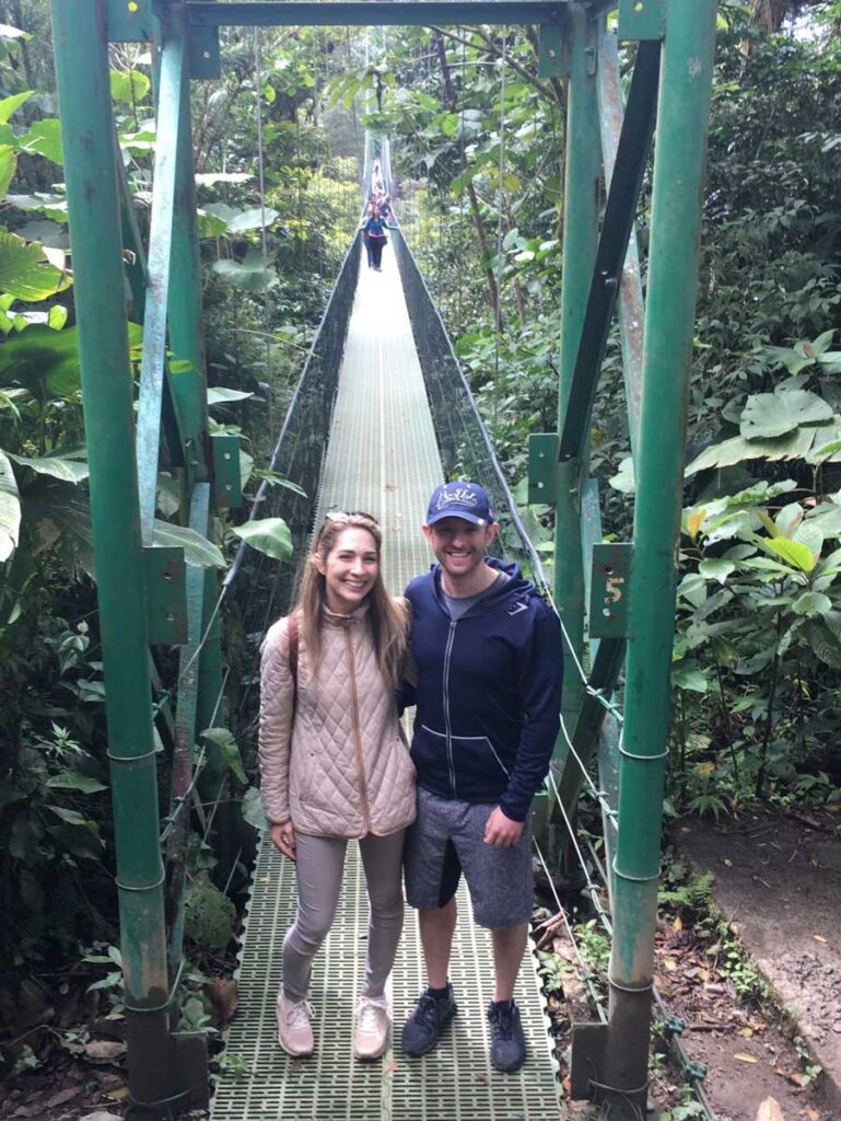 couple standing on bridge - cloud forest walk in Costa Rica