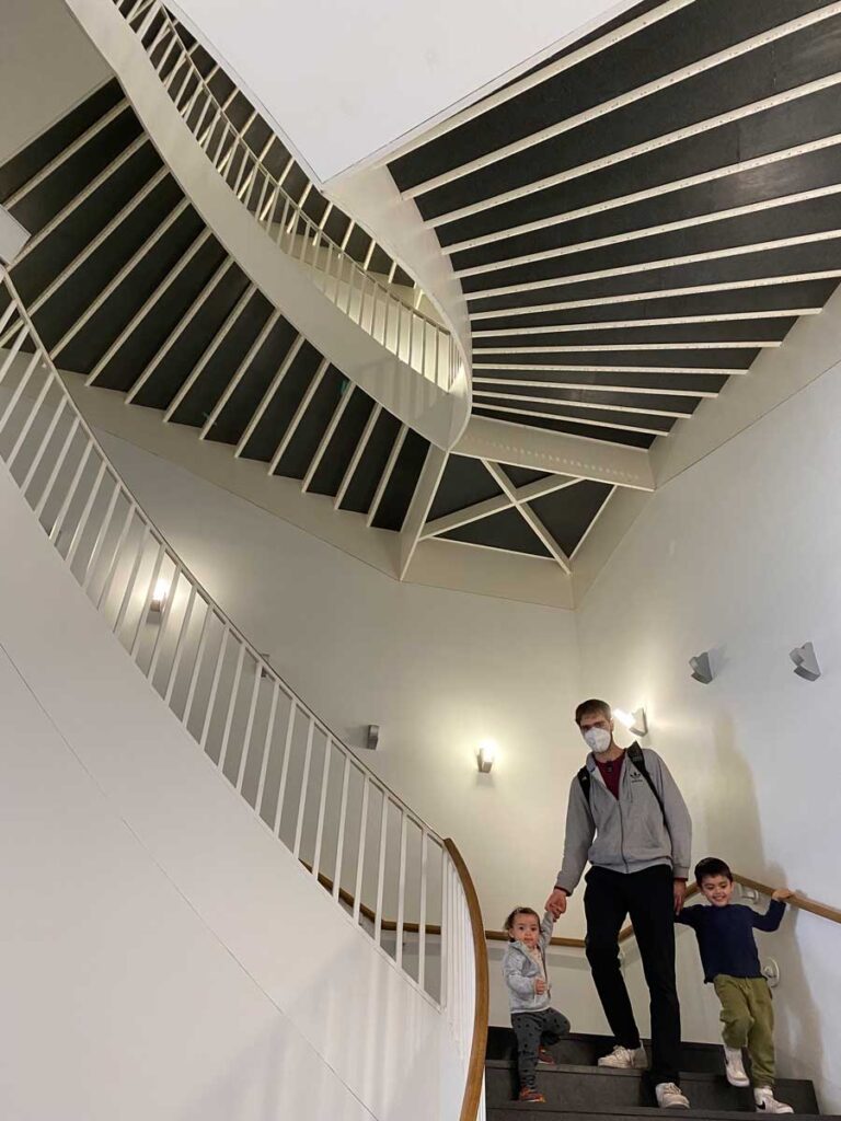 father and toddlers walking down stairs in Museum of Contemporary Art in Chicago