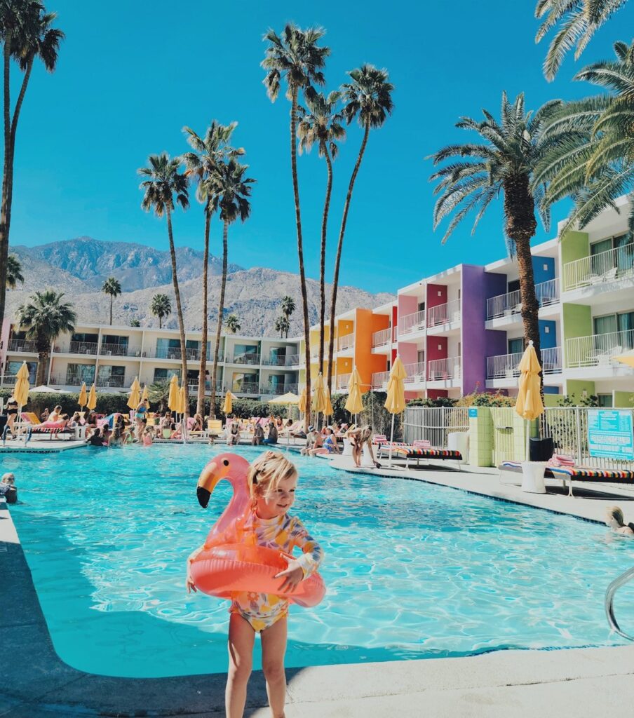 Toddler in front of pool with flaming floaty at The Saguaro - toddler friendly resort in Palm Springs