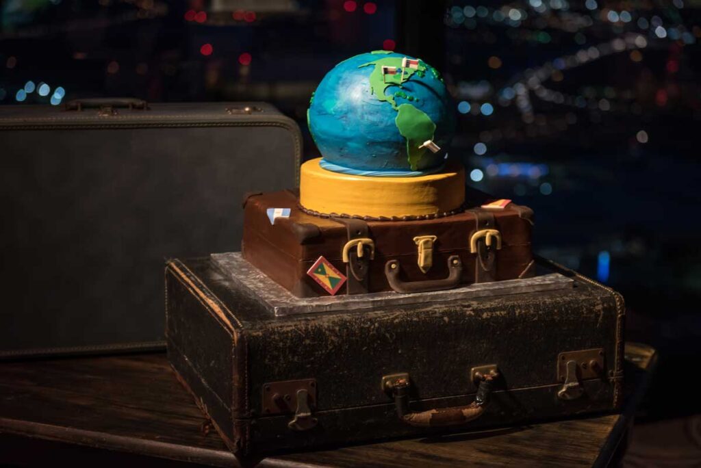 globe cake on vintage suitcases for travel themed baby shower cake