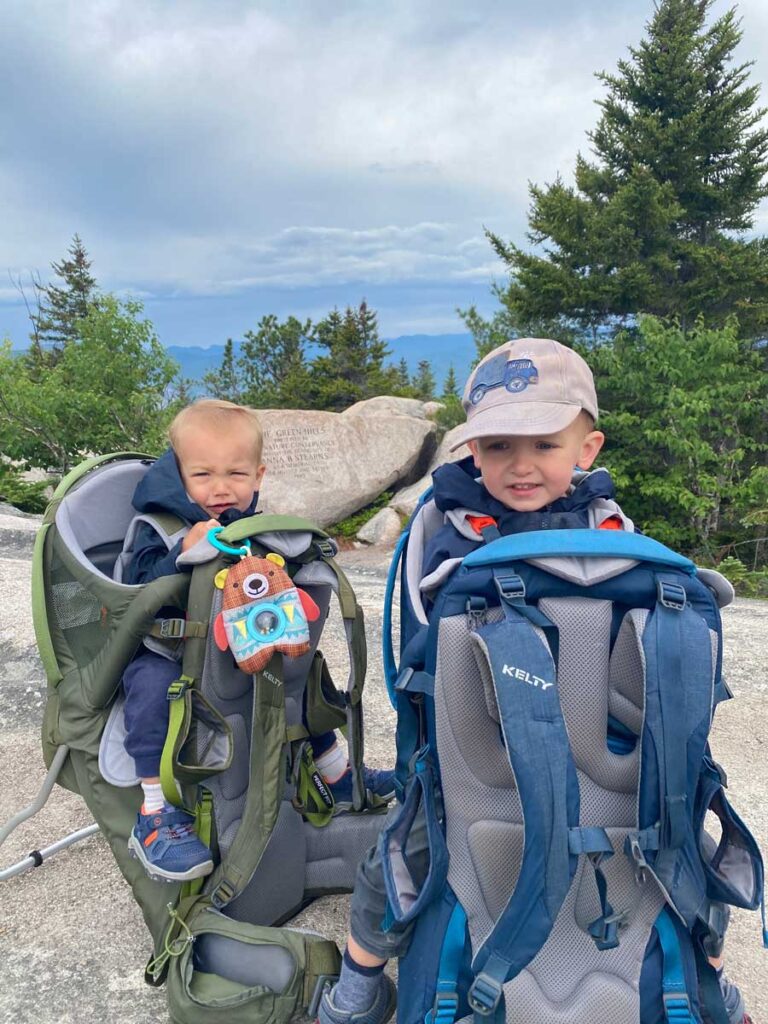 baby and toddler in hiking backpack carriers