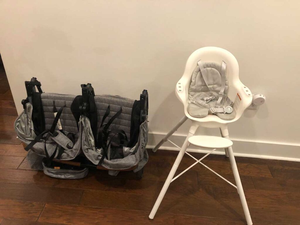 Zoe Twin Stroller folded next to a chair for size comparison