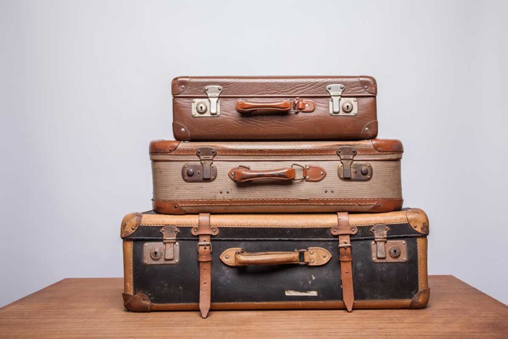 three vintage suitcases piled that make excellent travel themed party decorations