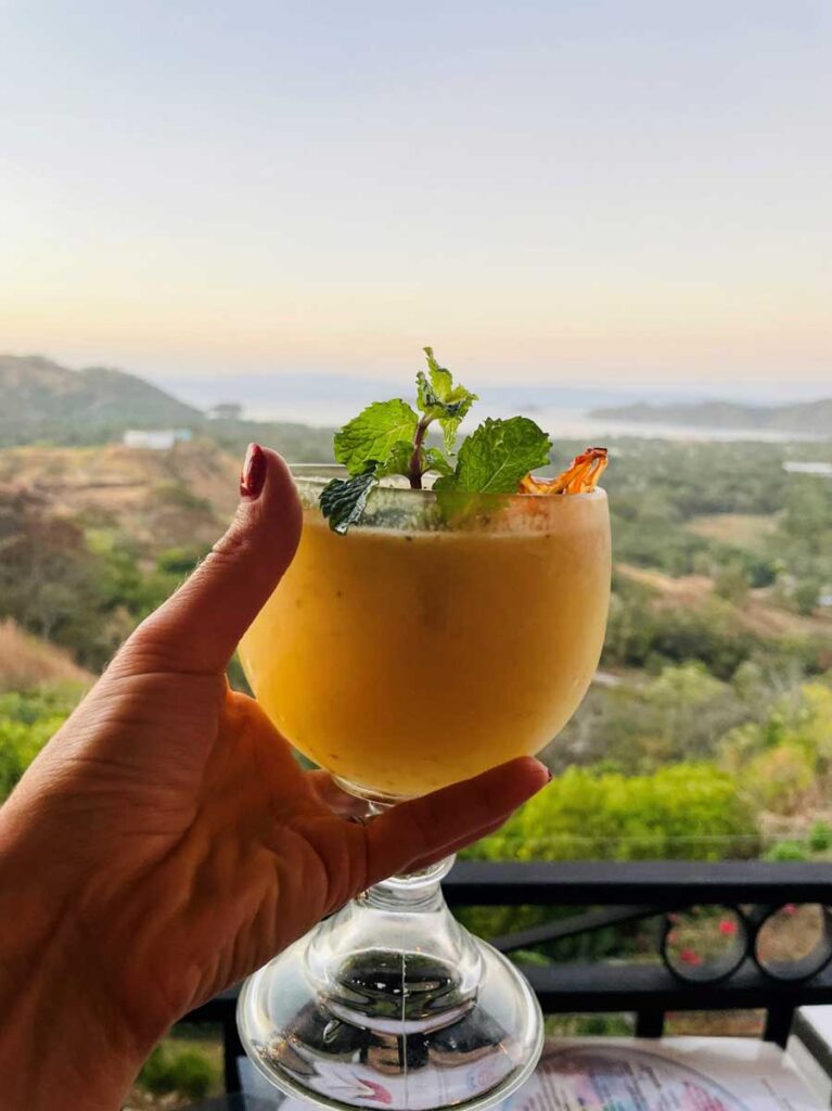 woman holding drink with view of Costa Rica in background