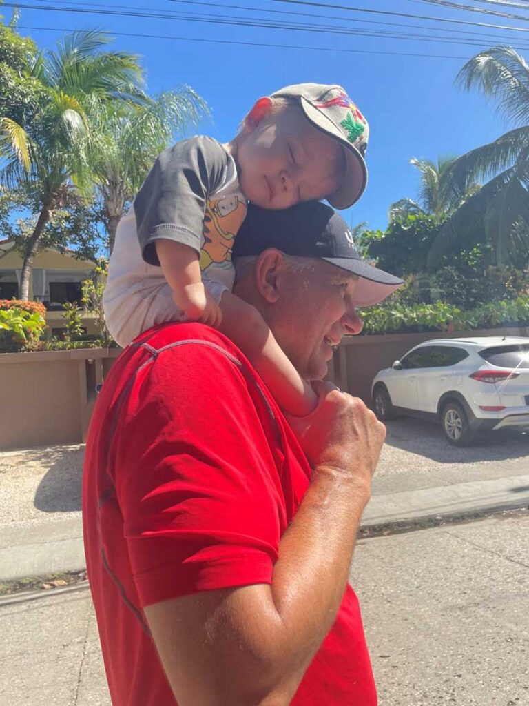 man holding sleeping baby while walking in Costa Rica