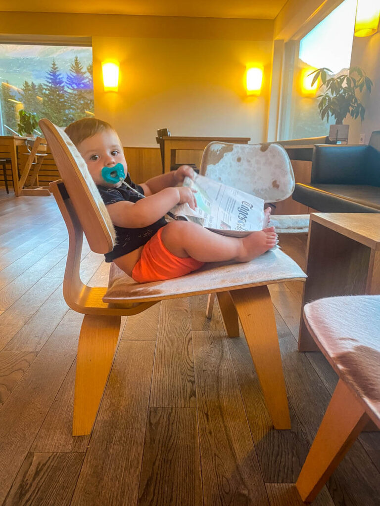 baby sitting on chair at Youth Hostel in Switzerland while on a family road trip through Europe.