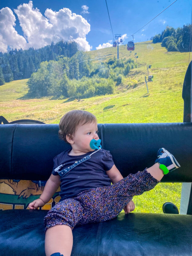 a baby enjoys a ride up the Hundle Bergbahn cable car on a European road trip.